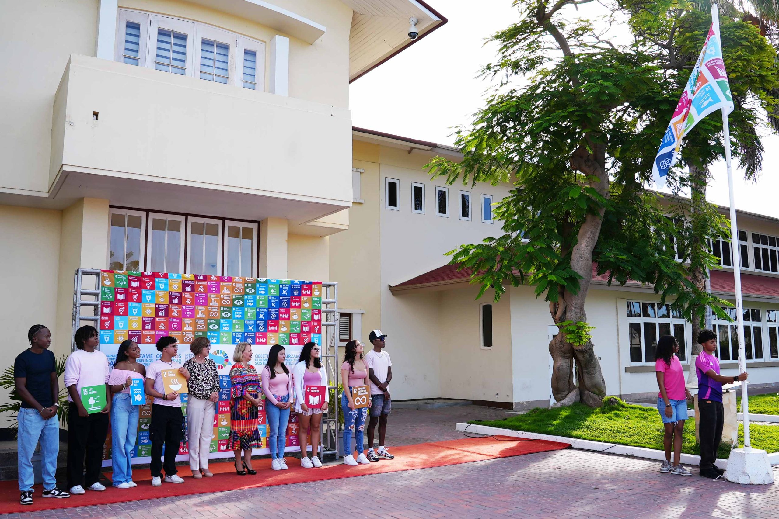 Prome Minister A Mustra Su Compromiso Cu Metanan Di Desaroyo Sostenibel Hisando E Bandera Cu Ta Representa E 17 Metanan 161 Sdg Flag Day 1 2 Scaled
